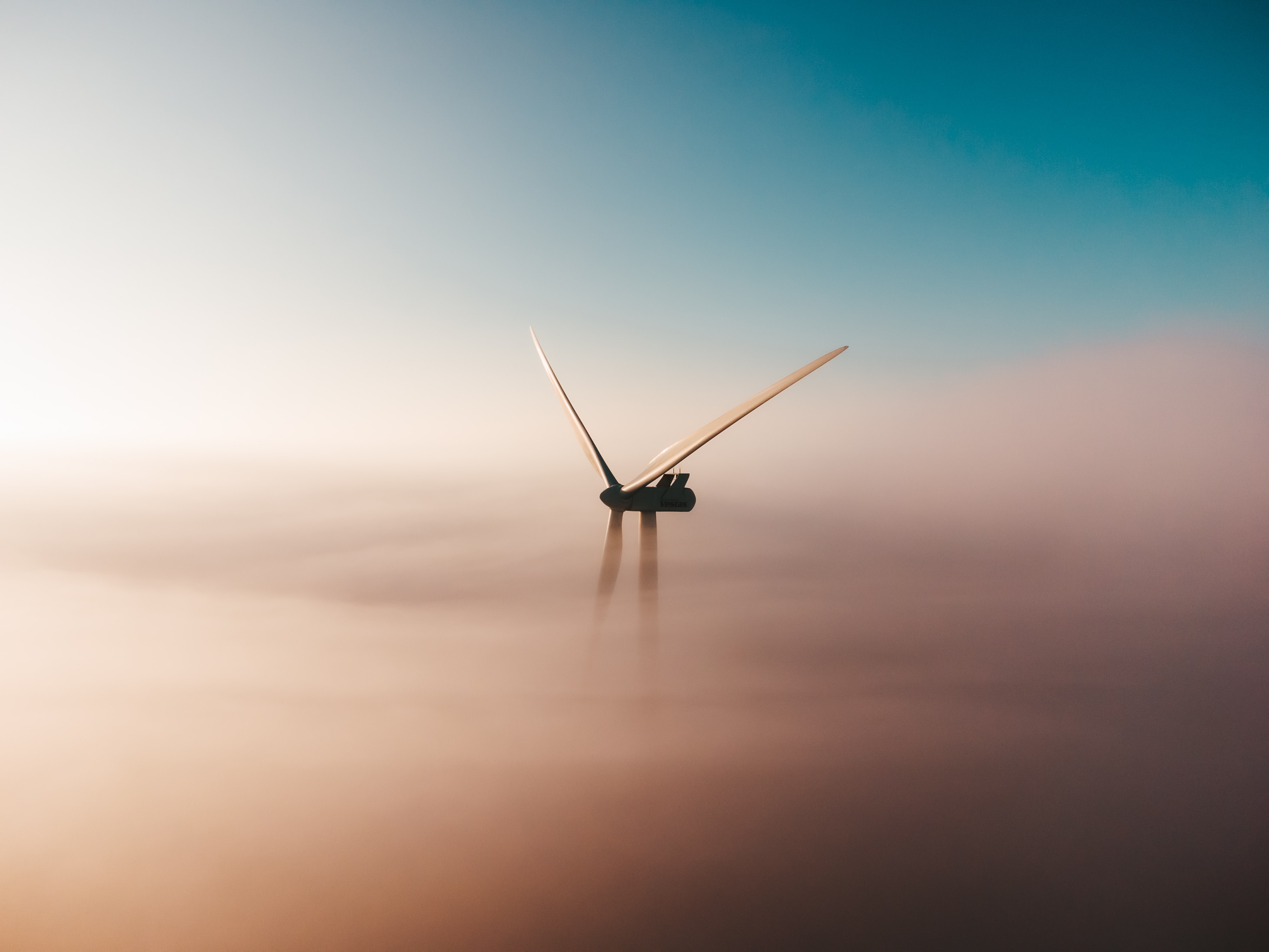 Titelbild "Klimaziele und Energiewende". Ein Windrad im Nebel. Quelle: unsplash.com/@sanderweeteling