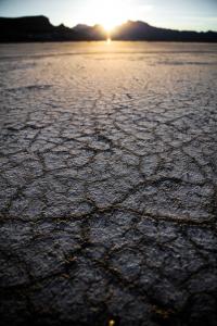 Trockener aufgerissener Boden, Sonne im Horizont. Quelle: Patrick Hendry auf Unsplash.com