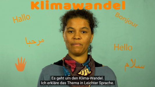 Eine junge Frau erklärt den Klimawandel in einfacher Sprache.