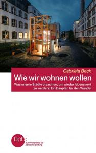 Buchcover: Ein modernes Holzhaus mit großen Glasflächen leuchtet am Abend zwischen alten Gebäuden in einer Straße. Titel: „Wie wir wohnen wollen“ von Gabriela Beck. Untertitel: „Was unsere Städte brauchen, um wieder lebenswert zu werden | Ein Bauplan für den Wandel“. Herausgeber: bpb.