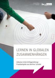Plakat auf dem Boden, zwei Hände bewegen Steine darauf.