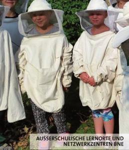 Zwei Kinder in Imkerkleidung.