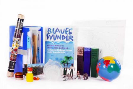 Hefte, Spielfiguren, Erdkugel. Die Materialkiste "Blaues Wunder". Bildquelle: Projekt "Eine Welt in der Schule" des Grundschulverbandes e.V.