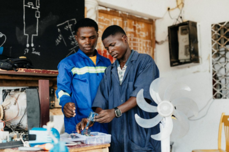 Zwei junge Männer in einer Werkstadt.