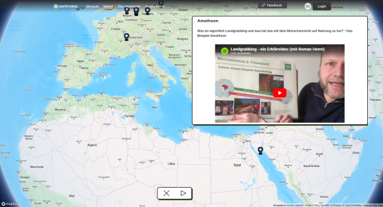 Screenshot einer interaktiven Weltkarte mit markierten Orten und einem geöffneten Informationsfenster. Dieses zeigt einen Beitrag zum Thema Landgrabbing mit eingebettetem Erklärvideo sowie begleitendem Text.