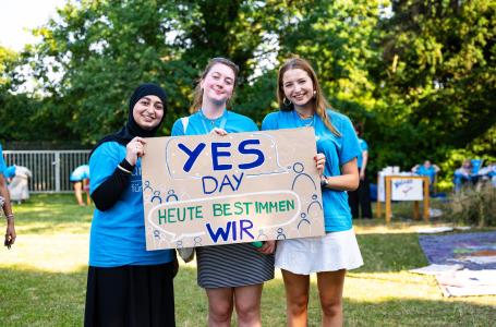 Schülerinnen halten Poster zum YES Day hoch