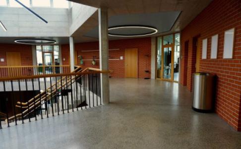 Innere eines Schulgebäudes mit Fluren und Treppen. Photo by Azzedine Rouichi on Unsplash