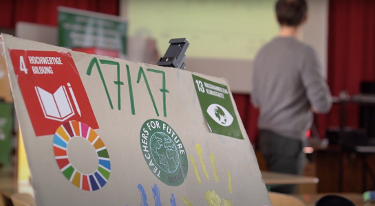 Graue Tafel mit SDGs und 17/17 Schriftzug.