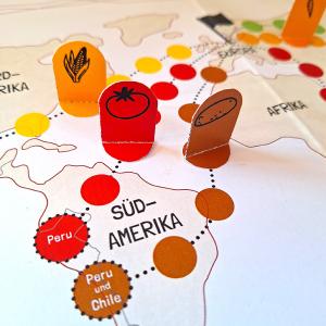 Spielfiguren auf einem Etappenweg auf einer Weltkarte.