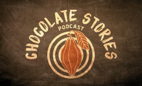 Goldener Schriftzug „Chocolate Stories“ und Kakaobohne auf Zielscheibe.