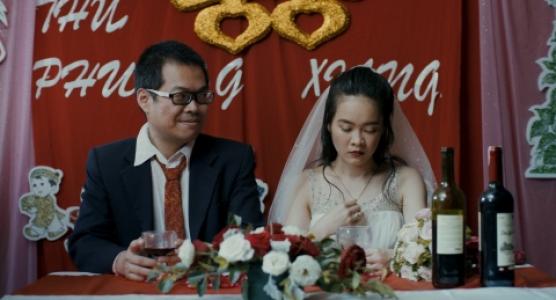 Trading Happiness. Die 17-Jährige Phuong sitzt neben ihrem doppelt so alten Verlobten und schaut traurig zu Boden. uelle: EZEF.