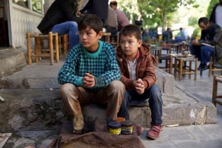Die beiden Brüder. Sie sitzen bei auf dem Bürgersteig, warten auf neue Aufträge in ihrem Job als Schuhputzer. Quelle: EZEF. 