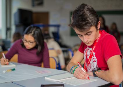 Zwei junge Menschen schreibend an einem Tisch sitzend. Bild Intercultural Learning Methodenbox. Quelle: http://intercultural-learning.eu