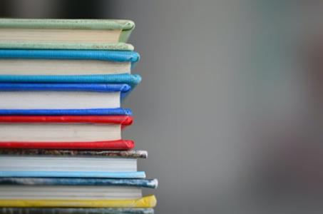 Bunter Bücherstapel. Quelle und Copyright: Kimberly Farmer auf unsplash.