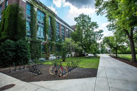 Mit Pflanzen bewachsenes großes Gebäude, davor Fahrradständer. Photo by Ryan Jacobson on Unsplash