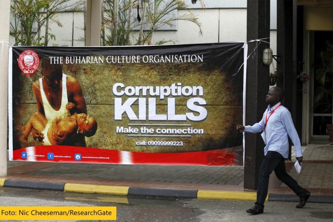 Mann geht an Plakat vorbei mit der Aufschrift "Corruption kills"